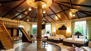 A spacious room with a large circular marble floor, a central column, and a staircase leading to an upper level. - Lohagarh Fort Resort (Amer)