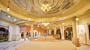 A luxurious bedroom with a large bed, ornate ceiling, and traditional decor. - Lohagarh Fort Resort (Amer)