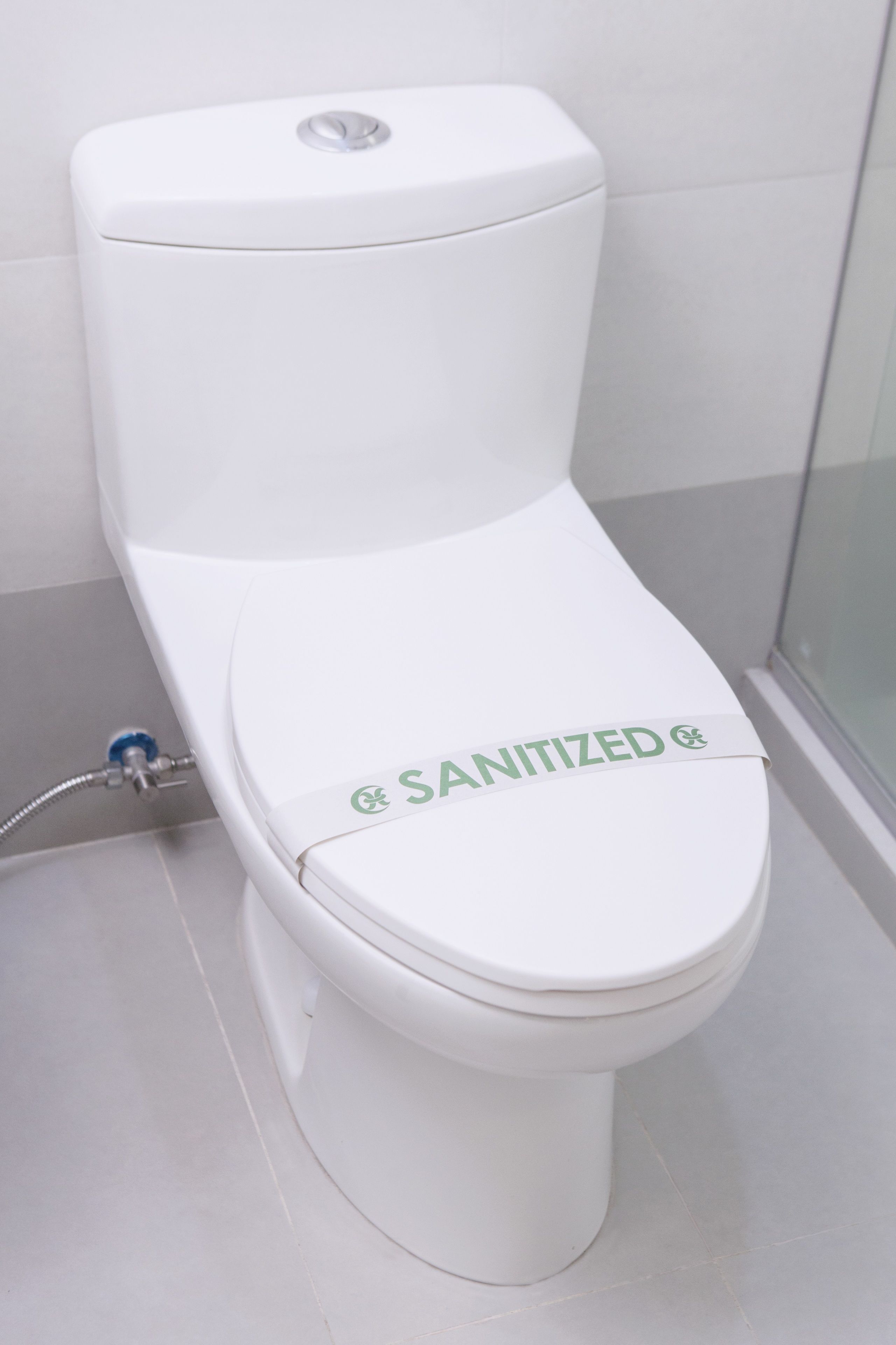 A white toilet with a "SANITIZED" label on the seat.