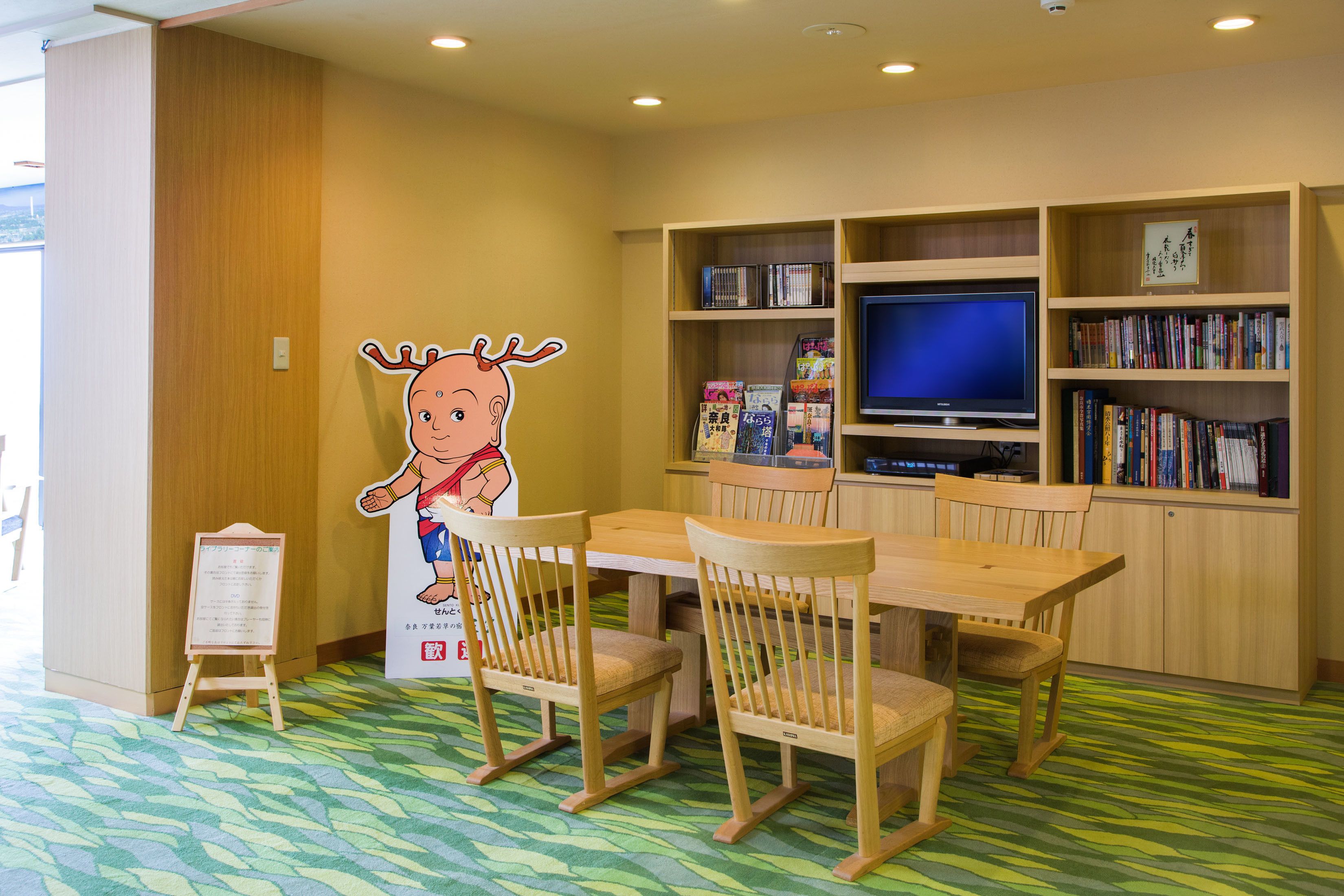 Una biblioteca con muebles de madera, un televisor y estanterías.