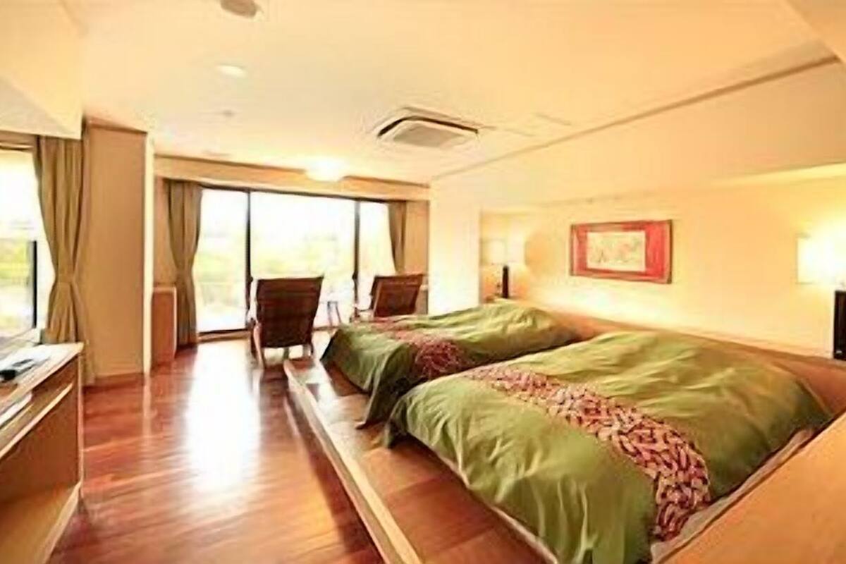 Ein Hotelzimmer mit zwei Betten, einem Schreibtisch und einem Stuhl.