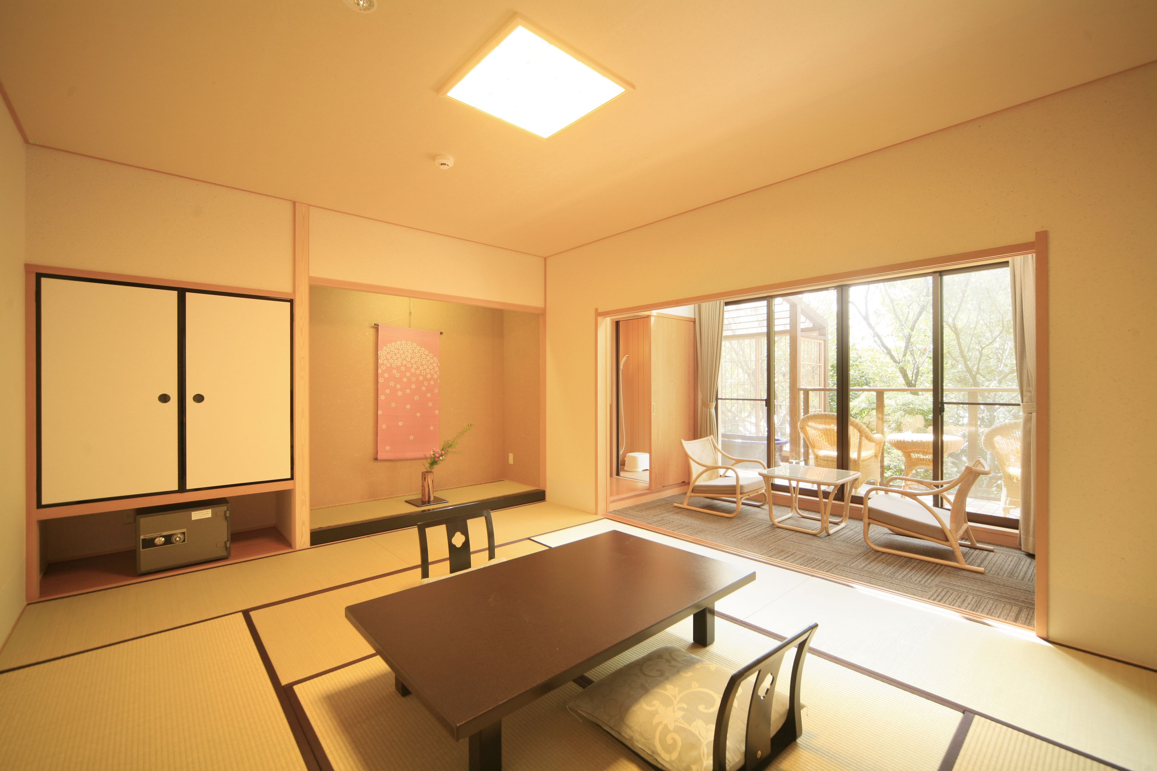 A traditional Japanese room with tatami flooring, a low table, and sliding doors.