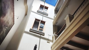A multi-story building with balconies and a large window.