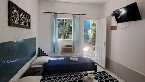 Una camera da letto con un letto, un ventilatore a soffitto, una TV e vista all'esterno.