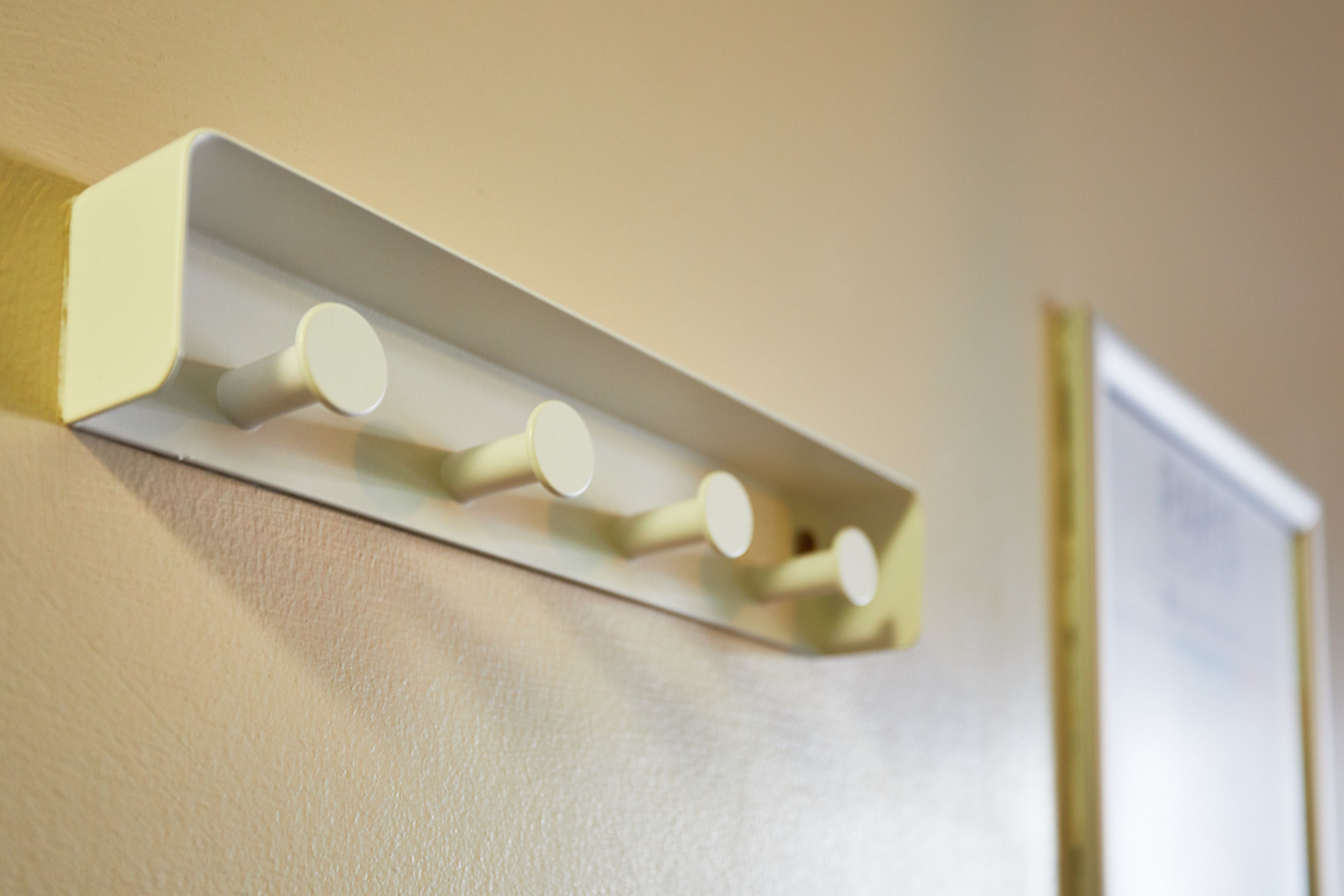 A wall-mounted light fixture with four cylindrical bulbs.
