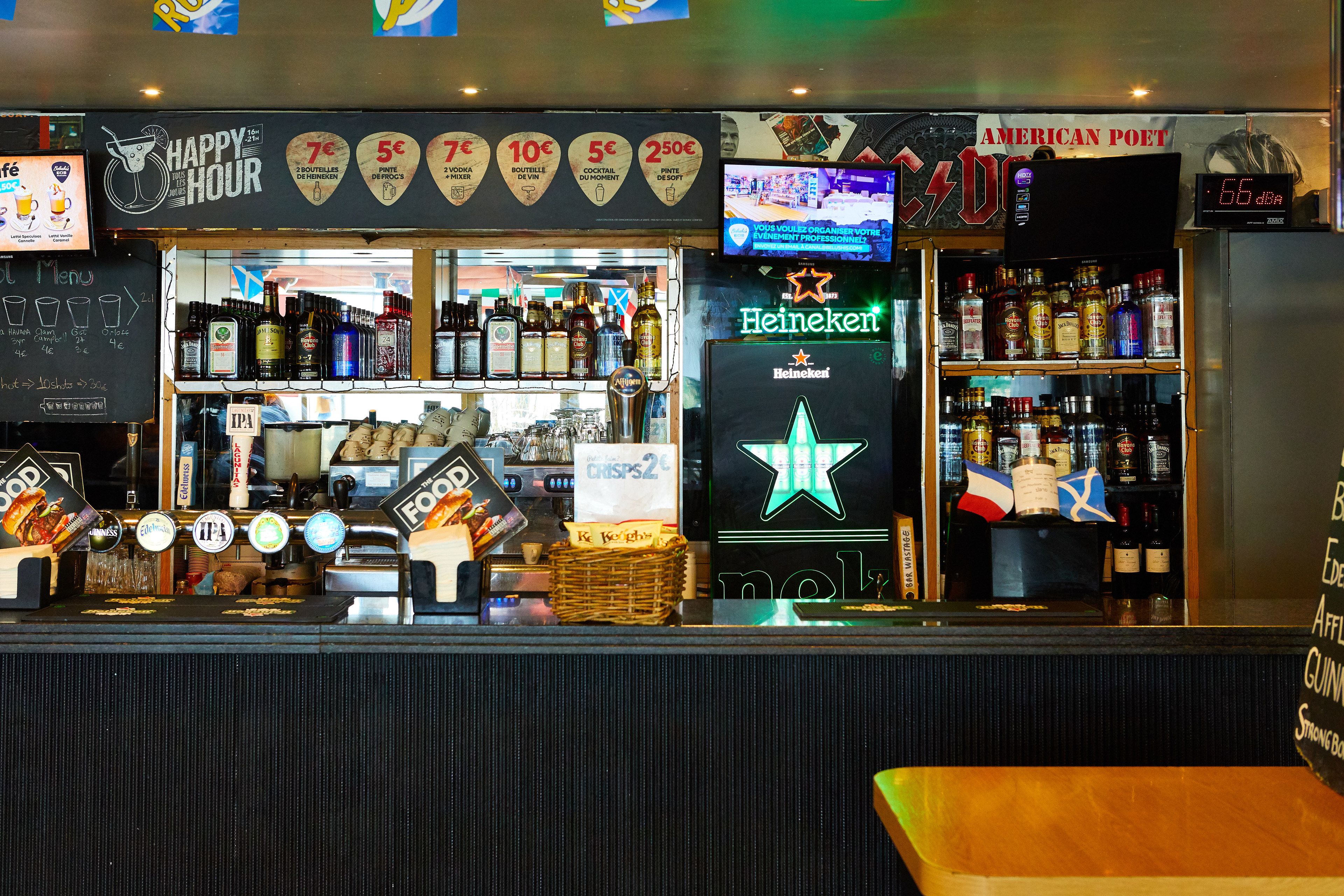 A bar with a Heineken sign, various bottles, and a digital clock displaying 6:55.