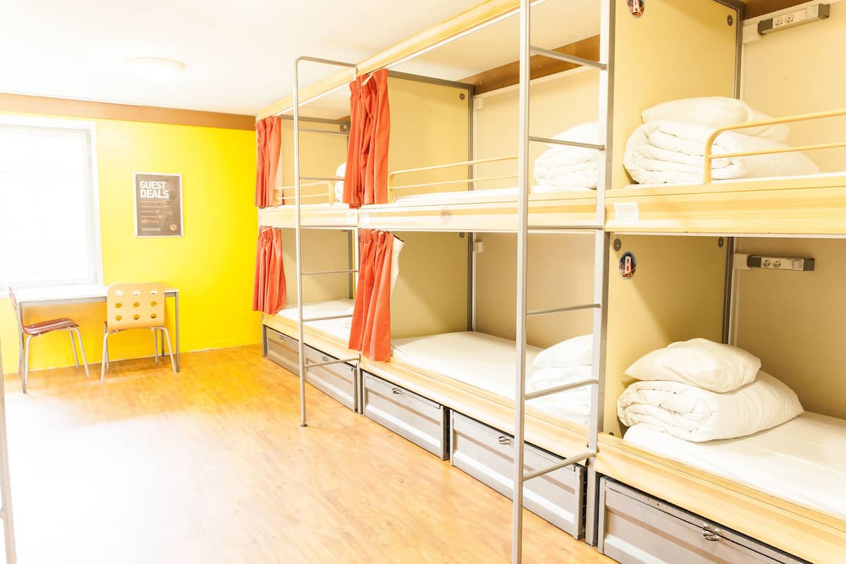 Un dormitorio con literas, un escritorio y una silla.