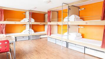 Une chambre de dortoir avec des lits superposés, un bureau et une chaise.
