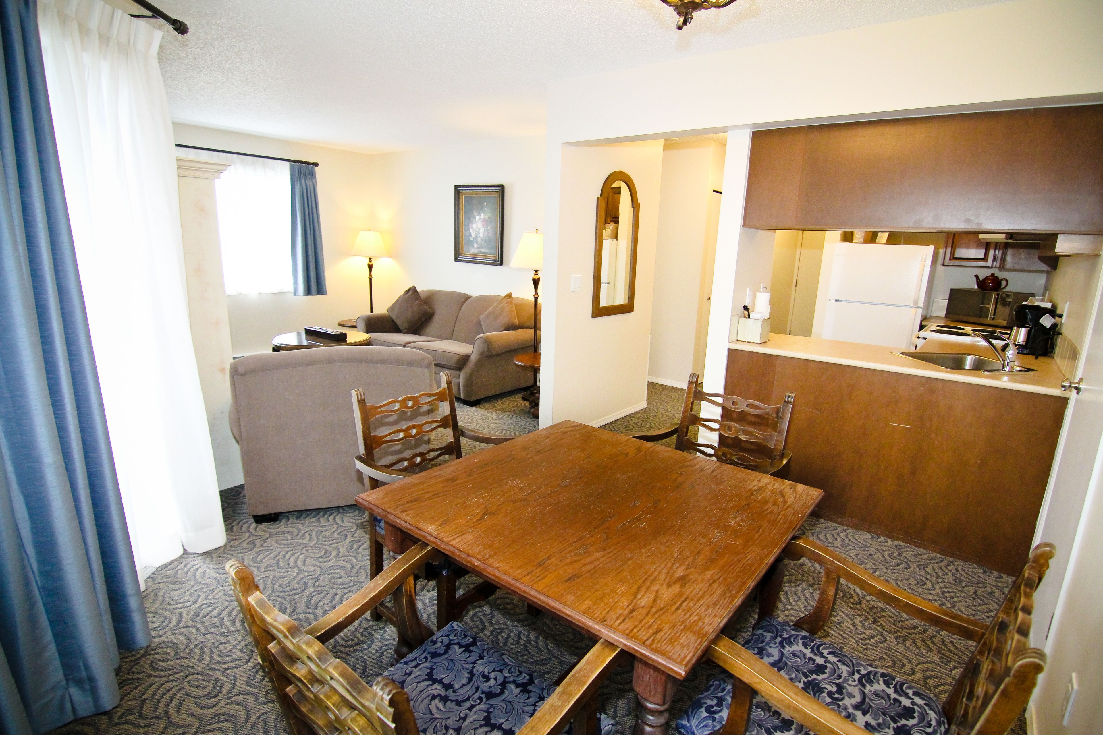 Un espacio habitable compacto con una mesa de comedor, sillas, un sofá y una kitchenette.