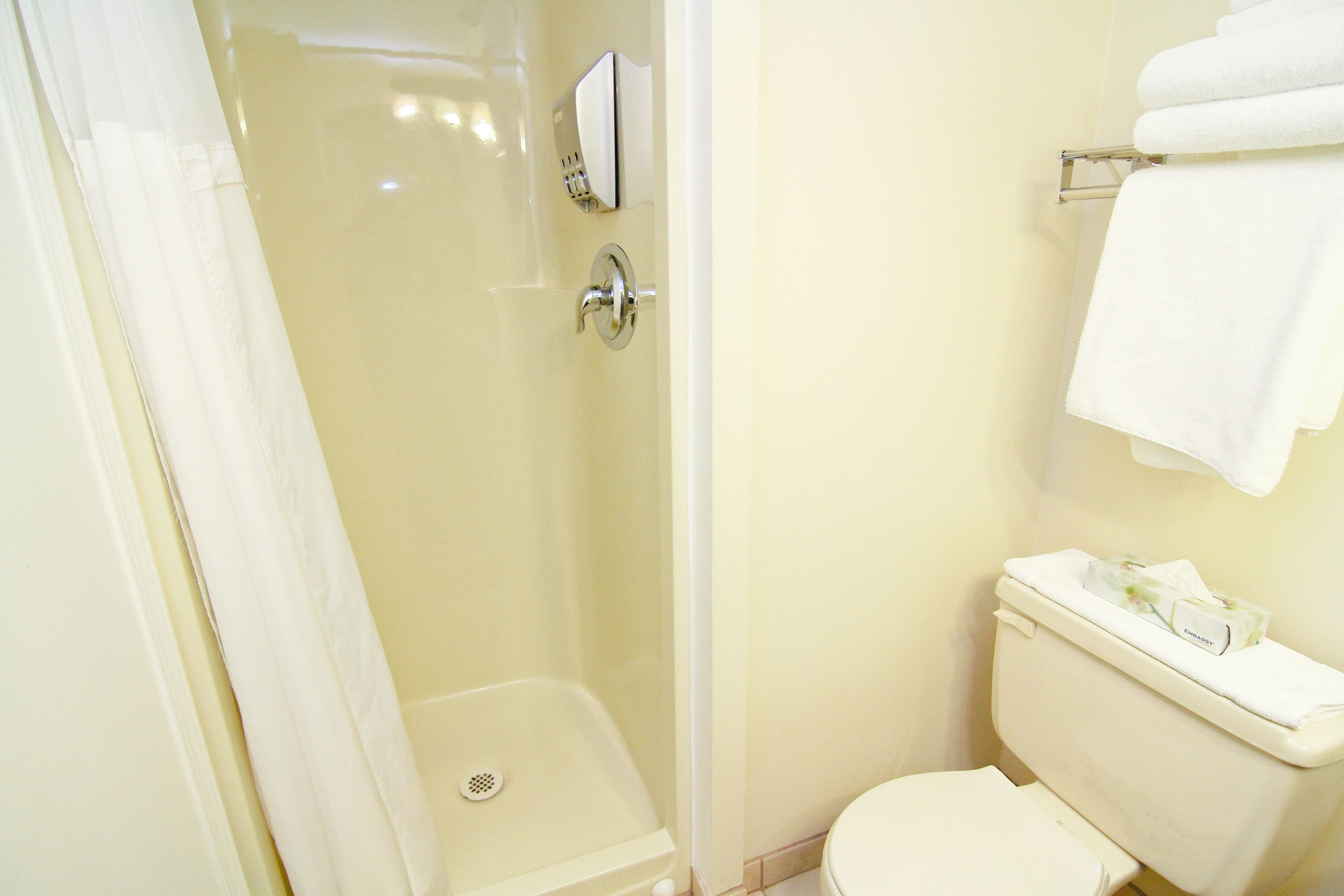 Ein Badezimmer mit Duschkabine, Toilette und Handtuchhalter.