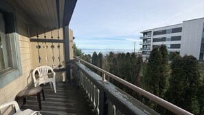 Un balcon donnant sur une forêt et un bâtiment moderne.