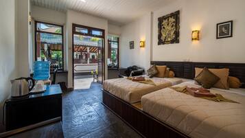 A hotel room with two beds, a coffee maker, a water dispenser, and a view of the outside.