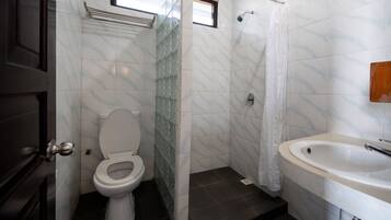 Un baño con inodoro, ducha y lavabo.