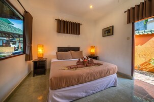 Una cama bien hecha con cabecera, dos lámparas de noche y una ventana con cortinas.
