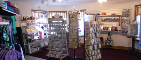 A retail store with various items on shelves and racks, including clothing and accessories.