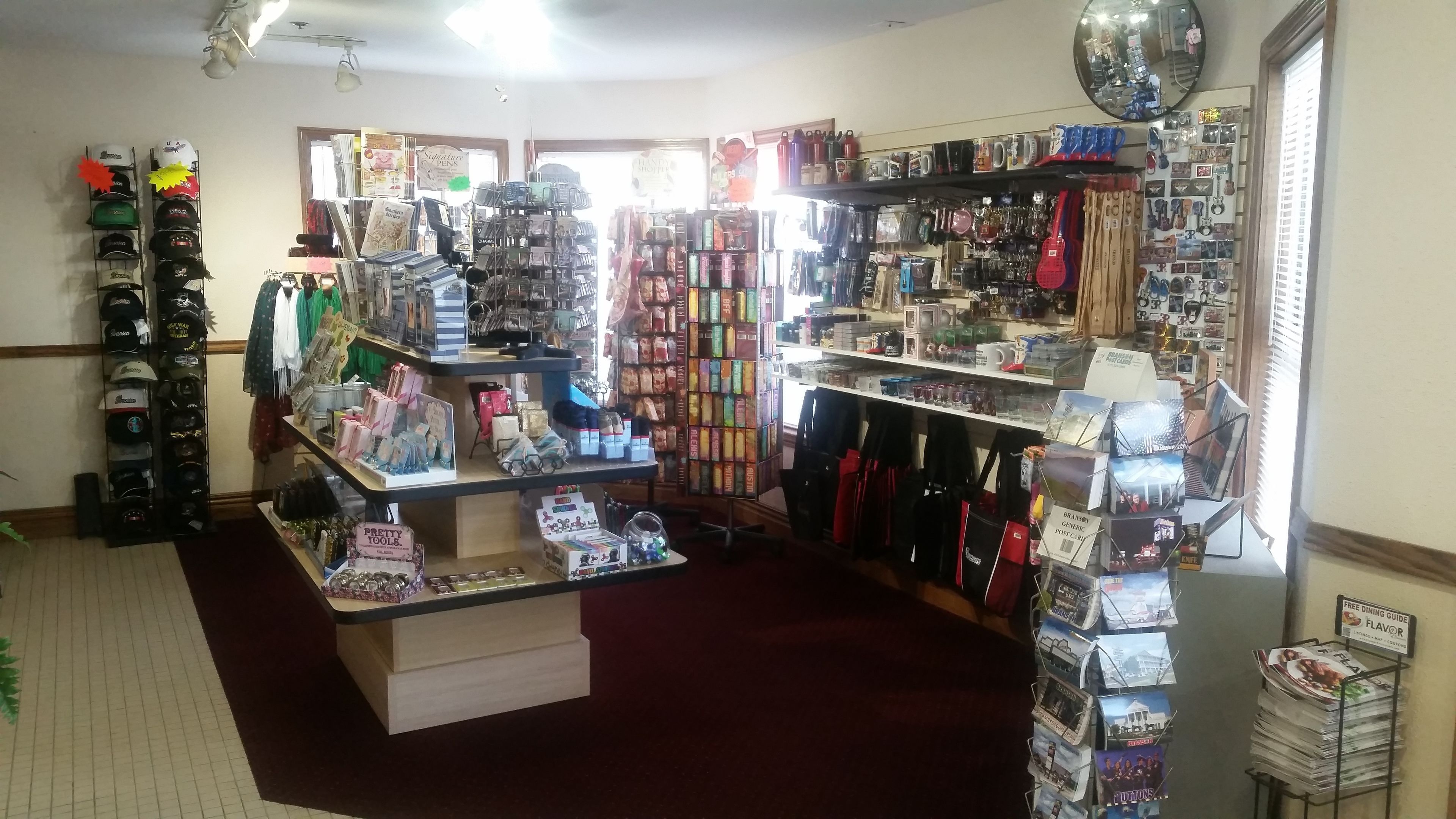 A retail store with various items on shelves and counters, including hats, bags, and greeting cards.