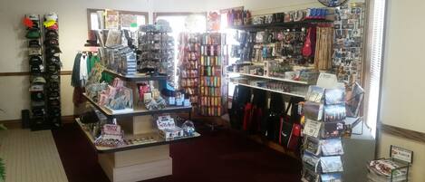 A retail store with various items on shelves and counters, including hats, bags, and greeting cards.