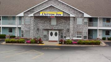A two-story Dutton Inn with a brick facade, a central entrance, and a balcony on the upper floor.