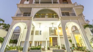 A multi-story building with a central archway, balconies, and a well-lit entrance. - 66 Residency - A Boutique Hotel (Jaipur)
