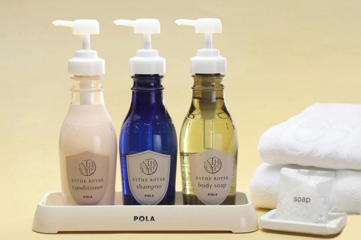 Three bottles of ESTHE ROYER products on a tray with a white towel and soap.
