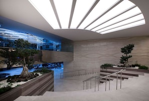 A modern interior with a staircase, a skylight, and a view of the outside.