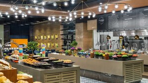 Un espace buffet proposant divers plats et un tableau affichant le menu.