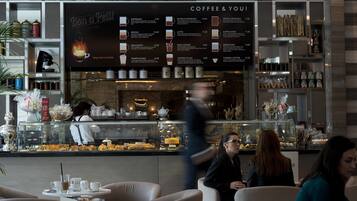 Una cafetería con un panel de menú que muestra diferentes opciones de café.
