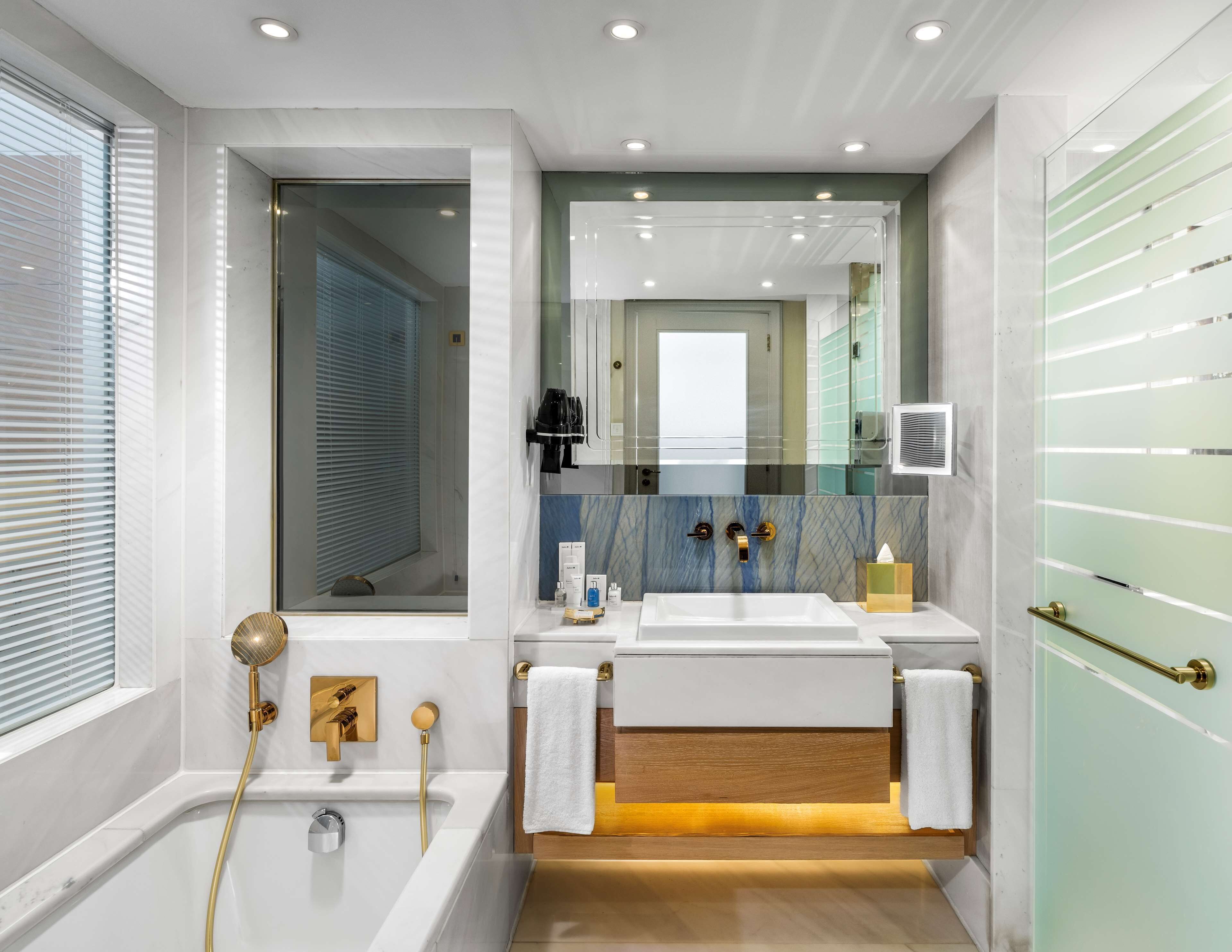 Une salle de bain moderne équipée d’une baignoire, d’une douche et d’un meuble-lavabo avec un miroir.