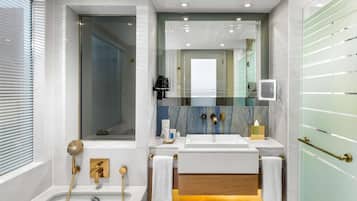 Une salle de bain moderne équipée d’une baignoire, d’une douche et d’un meuble-lavabo avec un miroir.