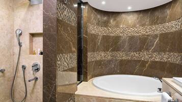 Une salle de bain moderne avec une baignoire sur pieds, un espace douche doté d’un pommeau de douche à main, et un meuble-lavabo avec un évier et un porte-serviettes.