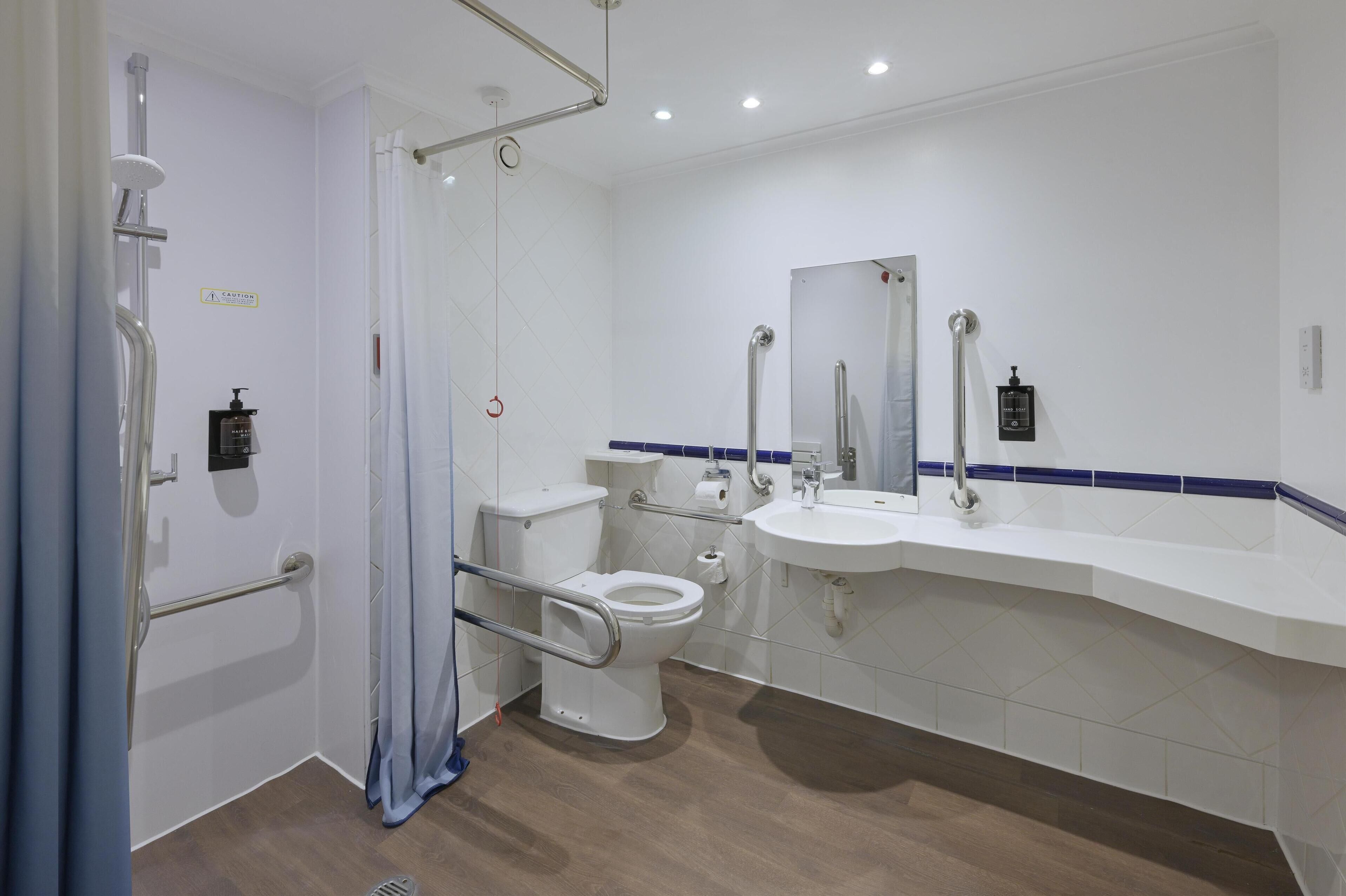 Un baño moderno con inodoro, lavamanos y zona de ducha.
