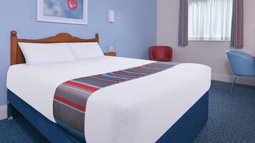 A hotel room with a large bed, a desk, a chair, a window with curtains, and a wall-mounted picture.