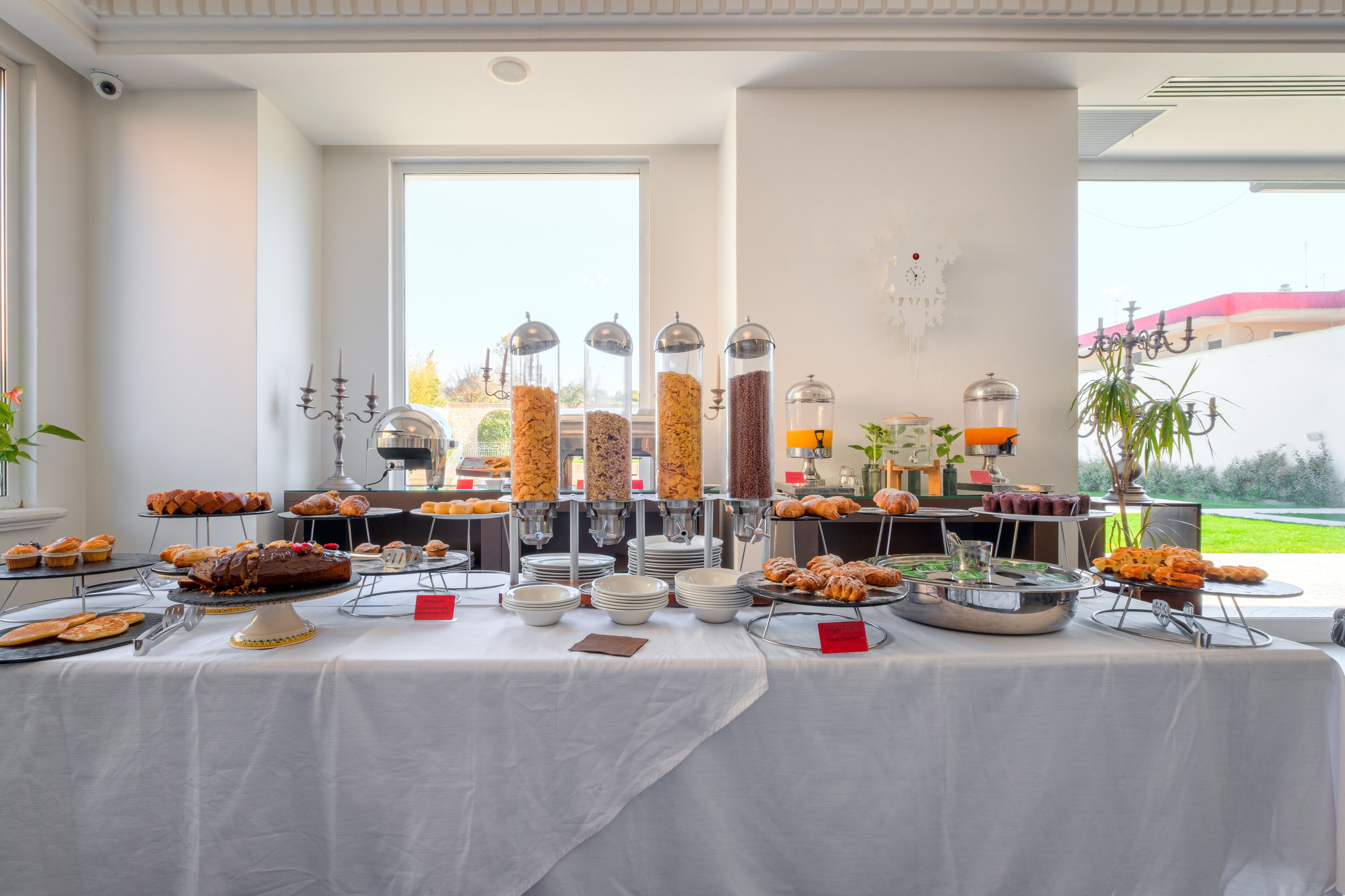 A buffet table with various food items and a view of the outdoors.