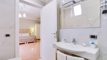 Une salle de bain moderne avec un lavabo blanc, un miroir et un porte-serviettes.