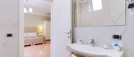 A modern bathroom with a white sink, mirror, and towel rack.