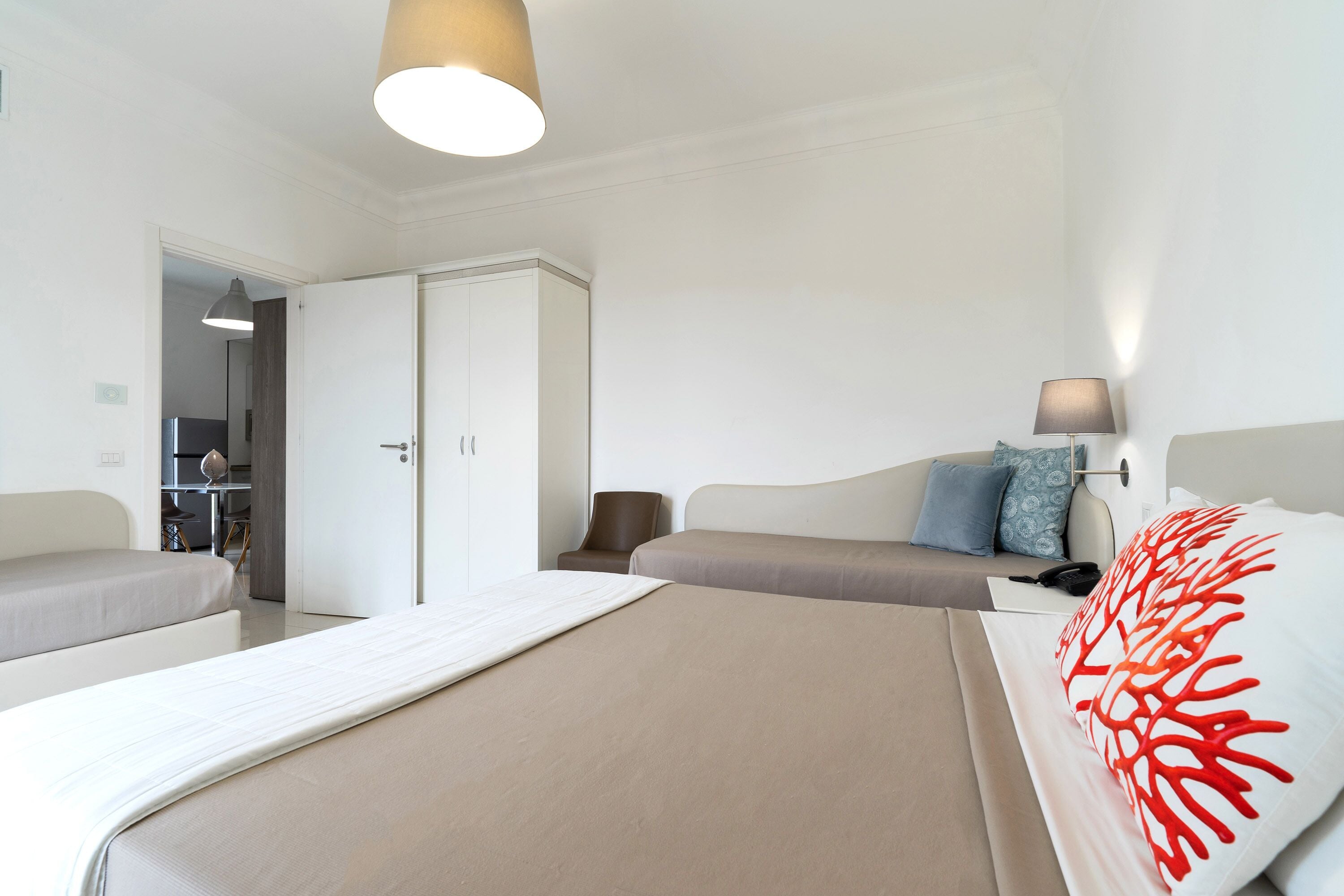 Una habitación de hotel con cama, sofá, escritorio y armario.