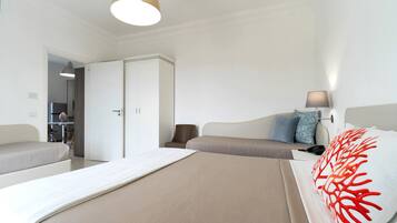 Una habitación de hotel con cama, sofá, escritorio y armario.