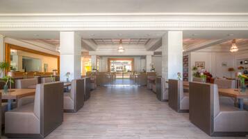A spacious hotel lobby with high ceilings, modern lighting, and a central open area.