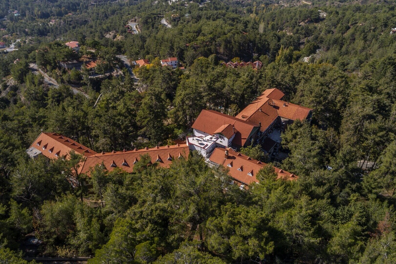 An aerial view of a residential area with houses surrounded by dense forest.