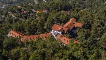 An aerial view of a residential area with houses surrounded by dense forest.