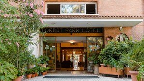 Indgangen til Forest Park Hotel med fliset gang og plantekasser.