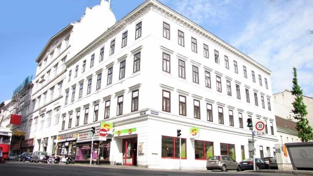 A multi-story white building with a classical architectural style, featuring a symmetrical facade with evenly spaced windows and a central entrance. - Hotel Pension Walzerstadt (Vienna)