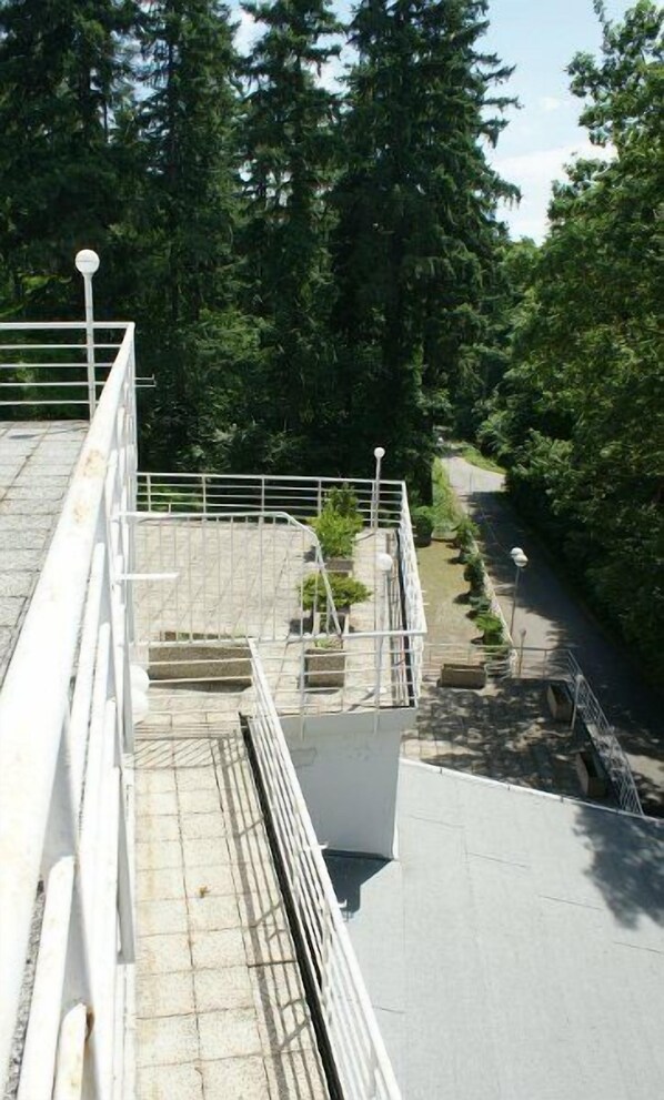 A rooftop terrace with a view of a forested area. - Interhotel America (Pisek)
