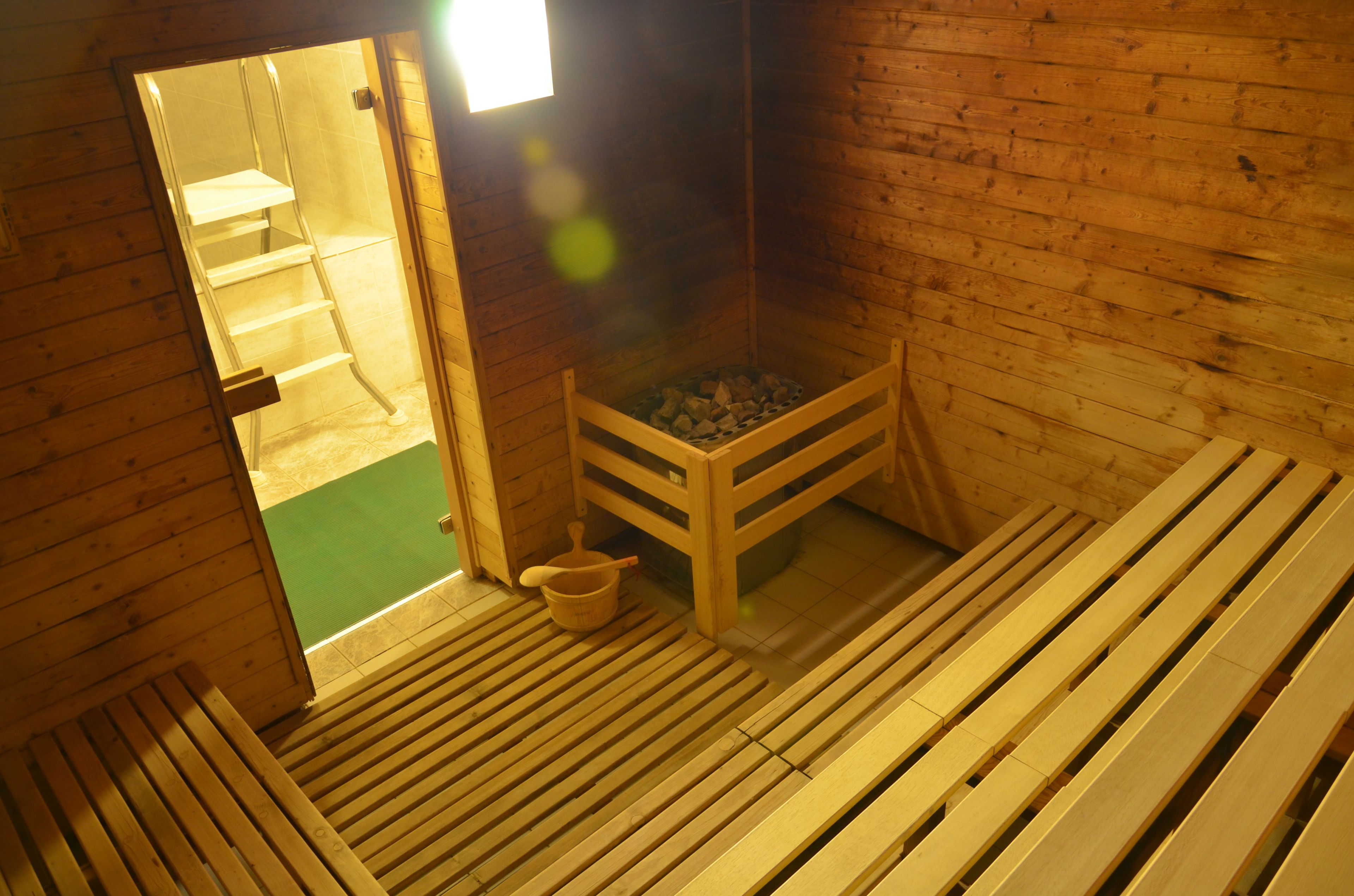 Una sauna de madera con bancos y una pequeña mesa de madera.