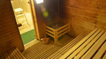 Una sauna de madera con bancos y una pequeña mesa de madera.