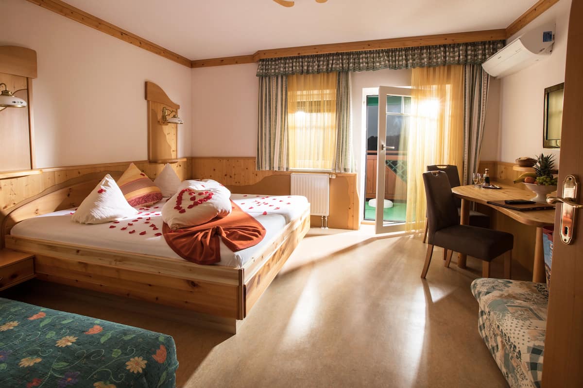 Ein Schlafzimmer mit Holzboden, einem Bett, einem Schreibtisch und einem Stuhl.