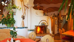 Un coin repas chaleureux avec une table en bois, des chaises et une cheminée.