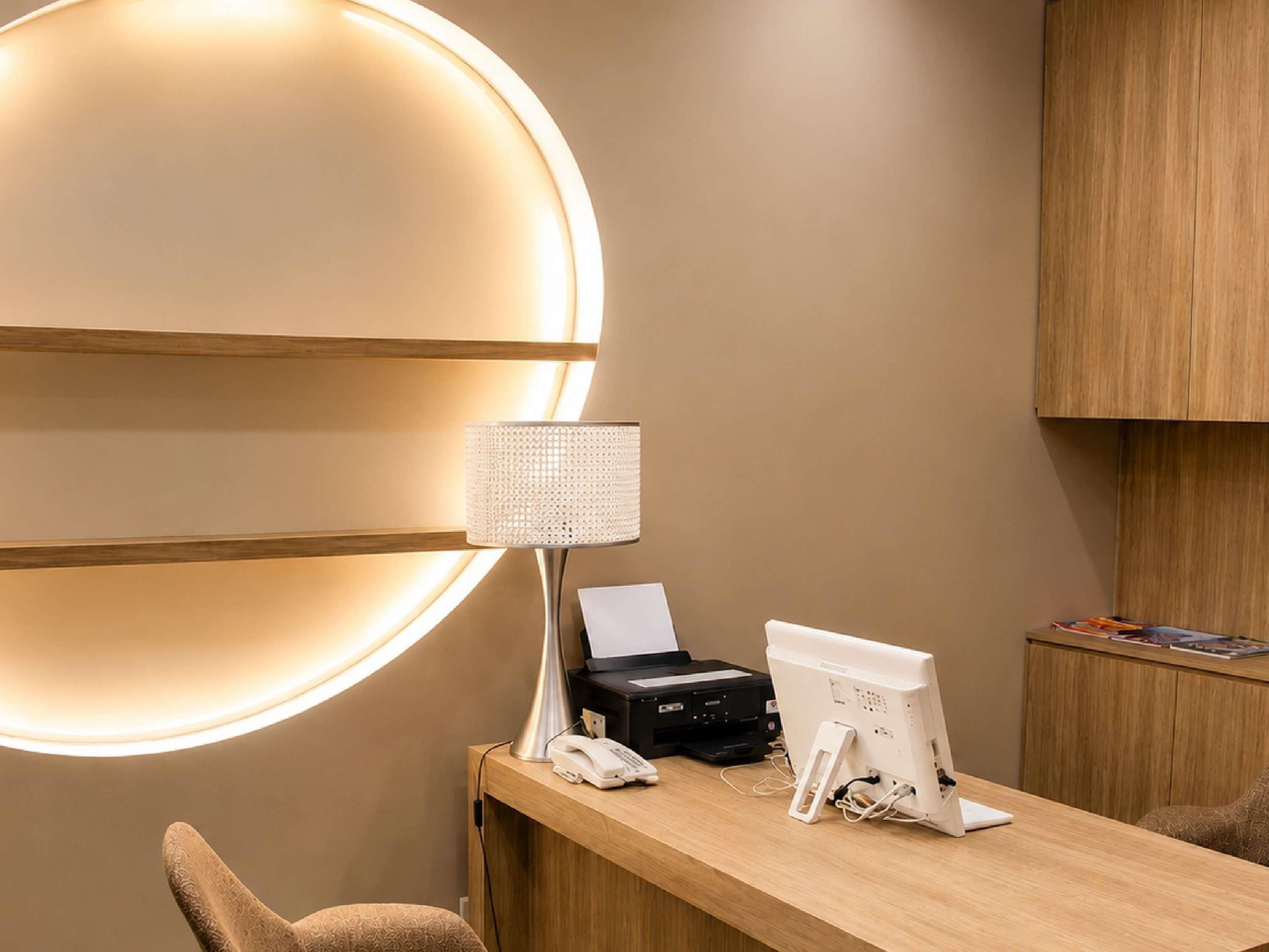 Ein Empfangsschalter mit moderner Lampe, Drucker, Telefon und Computermonitor.