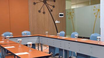 A conference room with a long table, chairs, and a wall with a dandelion design.