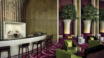 A bar area with stools, a counter, and a large potted plant.
